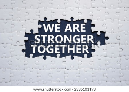 We are stronger together symbol. White puzzle with words We are stronger together. Beautiful black background. We are stronger together concept. Copy space.