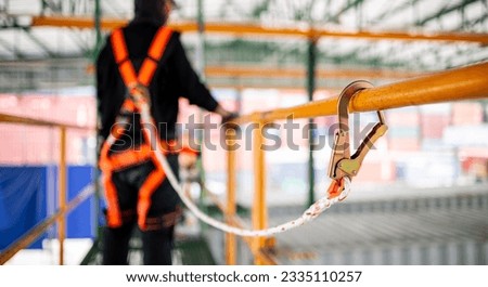 Construction worker wearing safety harness and safety line working at high place Royalty-Free Stock Photo #2335110257
