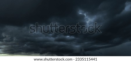 The dark sky with heavy clouds converging and a violent storm before the rain.Bad or moody weather sky and environment. carbon dioxide emissions, greenhouse effect, global warming, climate change Royalty-Free Stock Photo #2335115441