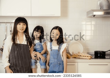 portrait group of asian mother and daughter taking at home kitchen happy together
