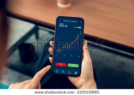 Businessman trader using smartphone with stock market investments and graph on screen to analyze trading data, buy or sell and checking price on mobile application. Royalty-Free Stock Photo #2335150005