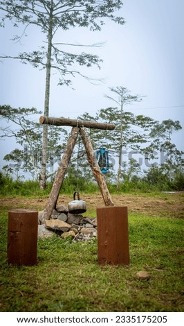 a picture of a kettle and a lamp on a campfire pit at Keningau campground.