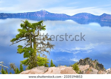 Oregon’s shimmering blue gem. Artists, photographers, and sightseers gaze in wonder at its blue water and stunning setting atop the Cascade Mountain Range.its purity—fed by rain and snow. Royalty-Free Stock Photo #2335194853