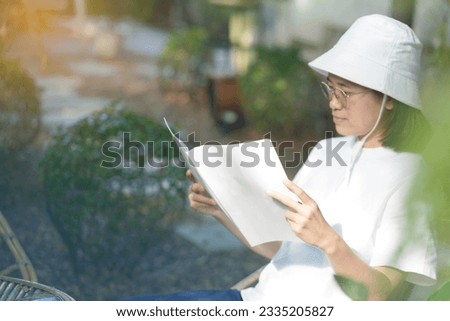 Close up and selective focus teenage girl holding and reading mock up book or magazine at garden.
