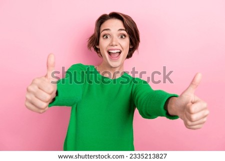 Photo of pretty impressed girl dressed green sweater showing you two thumbs up open mouth isolated pink color background