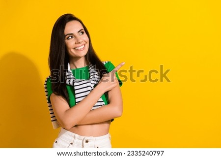 Photo of dreamy adorable lady wear green t-shirt looking pointing finger empty space isolated yellow color background