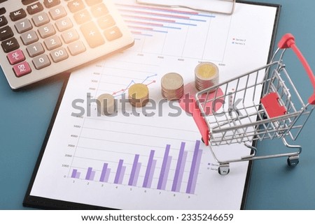 There are calculators, coins, and shopping carts on the data chart Royalty-Free Stock Photo #2335246659