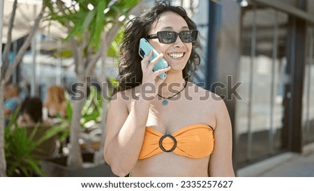 Young beautiful hispanic woman tourist smiling confident talking on smartphone at park