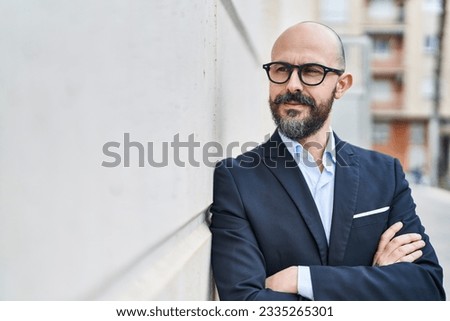 Young bald man business worker standing with arms crossed gesture at street Royalty-Free Stock Photo #2335265301