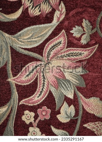 Close-up of a floral pattern on a burgundy fabric