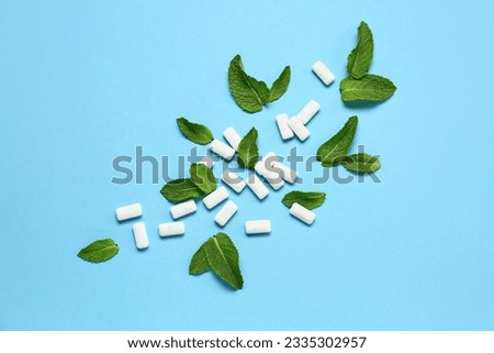 Fresh chewing gums with mint on blue background Royalty-Free Stock Photo #2335302957