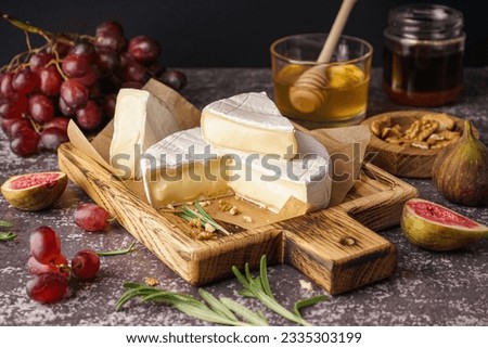 Wooden board with tasty Camembert cheese on table Royalty-Free Stock Photo #2335303199