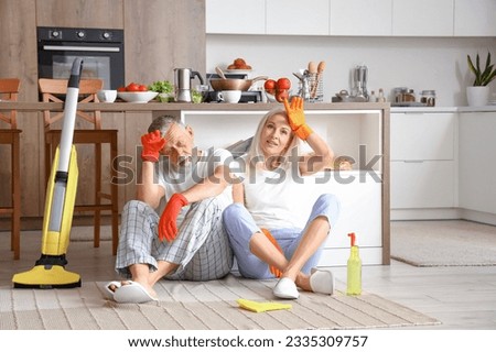 Tired mature couple after cleaning in kitchen