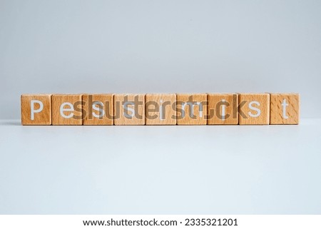 Wooden blocks form the text "Pessimist" against a white background. Royalty-Free Stock Photo #2335321201