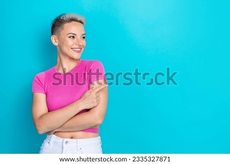 Photo portrait of attractive young woman finger point look empty space wear trendy pink clothes isolated on aquamarine color background
