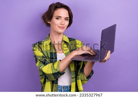 Photo of young model girl wearing green plaid jacket holding netbook it specialist working programmer isolated on purple color background