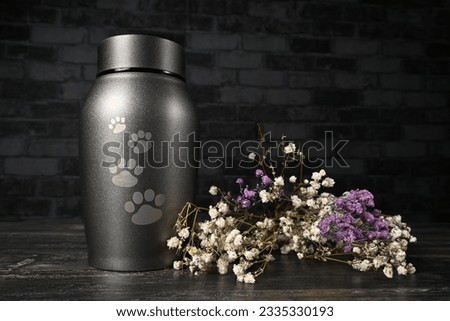  In remembrance of a pet. Pet urn beside a flower bouchet.