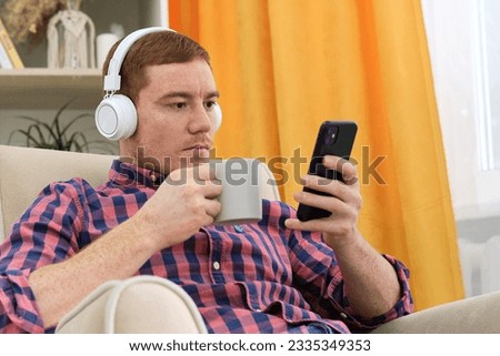 Tech-Savvy Auditory Experience: Redheaded Man Embraces the World of Audio Content. Finding Solace in Sound: Exploring the Benefits of Music and Podcasts for Relaxation Royalty-Free Stock Photo #2335349353