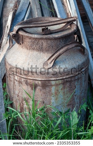 Old rusty milk canister in grass