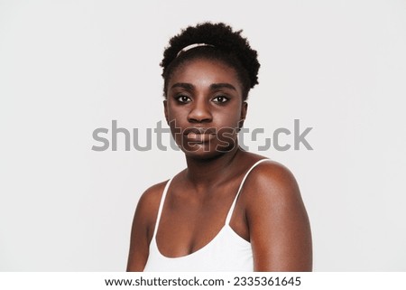 Black young woman posing and looking at camera isolated over white background