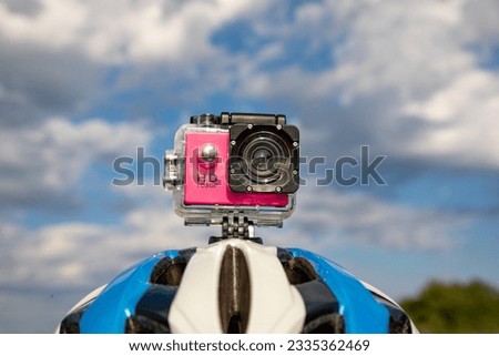 Action camera in a protective box on a bicycle helmet against a blue sky background. Royalty-Free Stock Photo #2335362469
