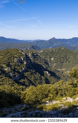 Landscape from the Ranc de Banes, near Sumene in the south of the Cevennes, on the Pic d'Anjeau, le Rochers de la Tude and, in the foreground, on the cliffs of the Combe Chaude Regional Nature Reserve Royalty-Free Stock Photo #2335389639