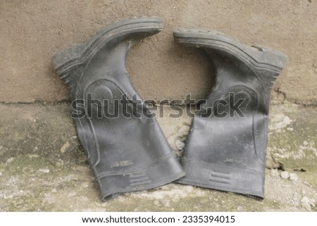 a pair of boots, located on the floor and against a wall