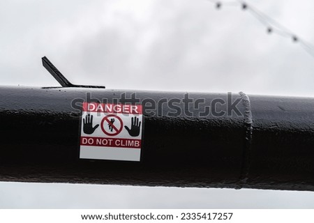 Danger do not climb sign on the black gas pipeline, safety and infrastructure concept illustration.
