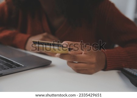 Close up female hands holding credit card and smartphone, young woman paying online, using banking service, entering information, shopping, ordering in internet store, doing secure payment