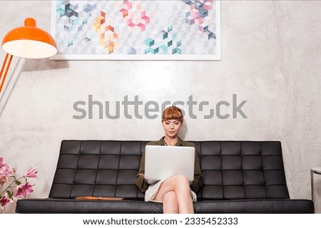 Creative businesswoman using laptop on sofa