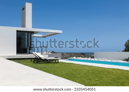 Lawn and lap pool along modern house Royalty-Free Stock Photo #2335454051