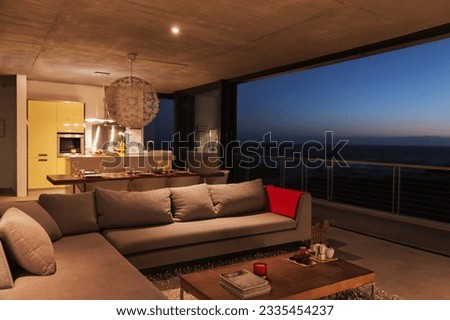 Sofa and dining table in modern living room overlooking ocean Royalty-Free Stock Photo #2335454237