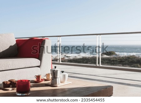 Breakfast on coffee table on modern patio overlooking ocean Royalty-Free Stock Photo #2335454455