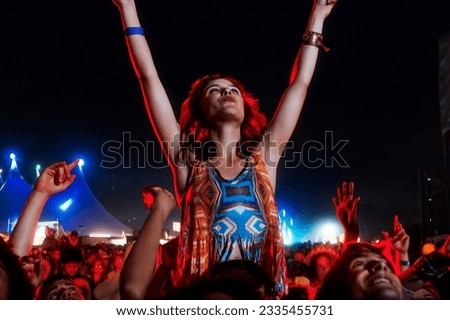 Cheering woman on man shoulders at music festival Royalty-Free Stock Photo #2335455731