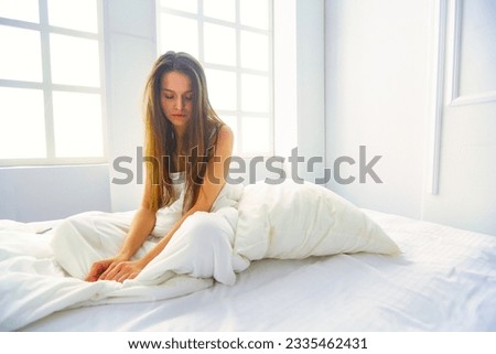 Young female feeling pain in bed. Royalty-Free Stock Photo #2335462431