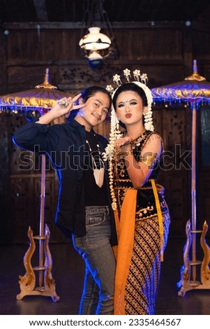 a Javanese dancer taking pictures with fans on stage at night