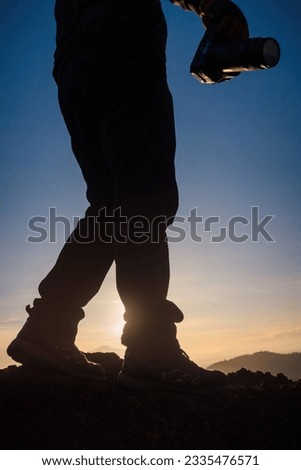 Capturing the Beauty of Sunrise: Photographer in the Silhouette of a Mountain