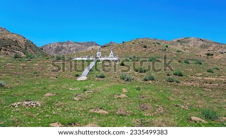 Big white heap of stones (aobao) with panoramic view on Daqing mountains in Inner Mongolia. Endless mountain chains. The slopes are overgrown with small bushes and grass. Desolated landscape. Religion Royalty-Free Stock Photo #2335499383
