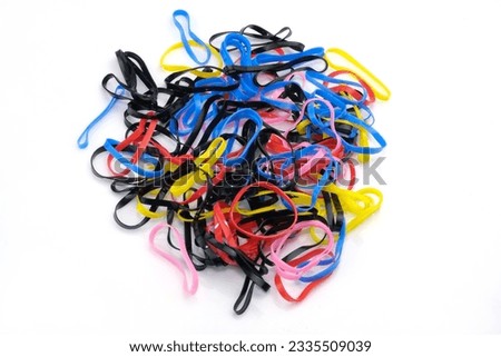 Rubber bands silicone colored thin on a white background. A set of small silicone hair ties. Elastic bands for braids of different colors. Multi-colored elastic bands for African braids Royalty-Free Stock Photo #2335509039