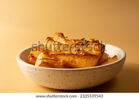 Top view Fried Cassava in Handcrafted White Ceramic Bowl on Yellow Studio Background