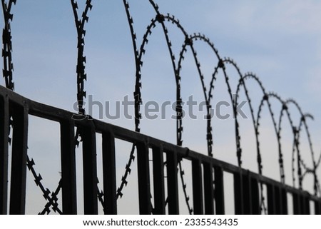 Barbed wire on a fence with sky background. Image of freedom. High quality photo