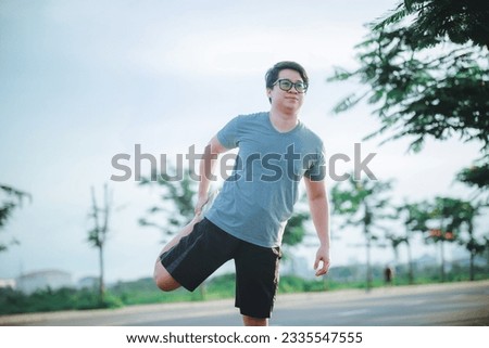 Man runner warm up outdoor. Handsome man in sportswear stretching his arms and legs for warming up his body before running. Image of exercise for good healthy.