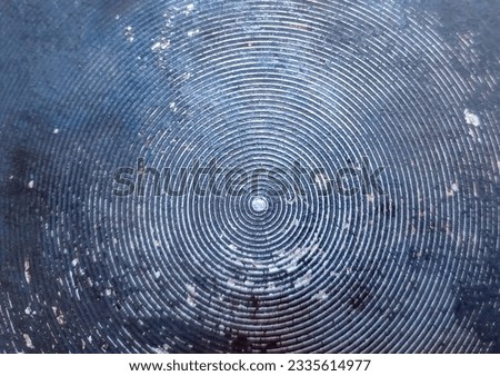 Photograph of metal surface with vintage circular wave pattern.