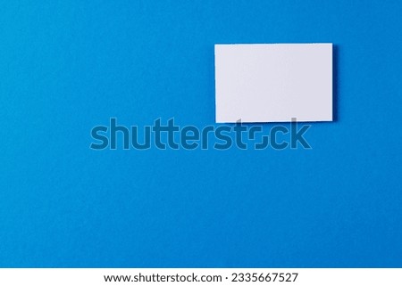 White business card with copy space on blue background. Business, business card, stationery and writing space digitally generated image.