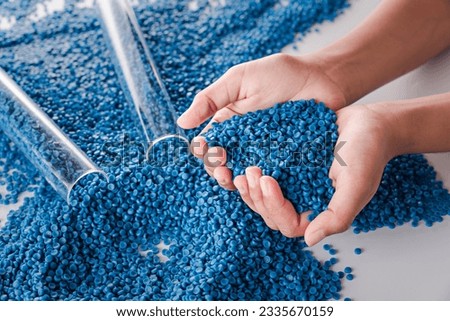 White plastic grain, plastic polymer granules,hand hold Polymer pellets, Raw materials for making water pipes, Plastics from petrochemicals and compound extrusion, resin from plant polyethylene. Royalty-Free Stock Photo #2335670159