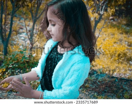 Dark present portrait photo of little girl on hill station. Selective focus and blur background outdoor in park. Happiness mood create good body gesture. Wearing black and white cloth.