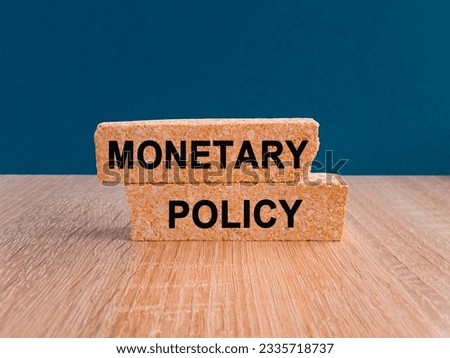 Concept words Monetary Policy on brick blocks. Ideas for Increase or Decrease interest rates, Stimulate the economy, Moneyless valuable. Beautiful wooden table, blue background