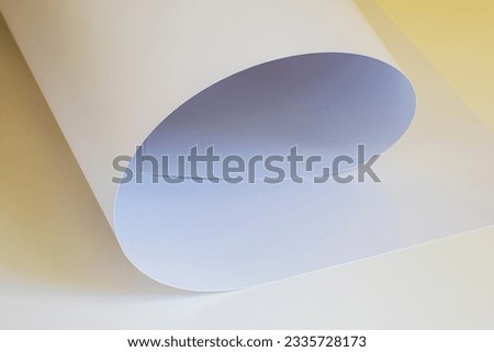 A large sheet of white paper in soft pastel colors with a yellow reflection.