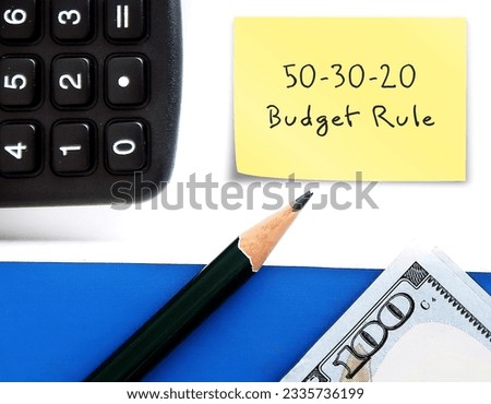 Cash dollars money, pencil and calculator with text written note 50 30 20 RULE , 50% NEEDS 30% WANTS 20% SAVINGS ,Rule of Thumb for allocating budget to reach financial goals Royalty-Free Stock Photo #2335736199