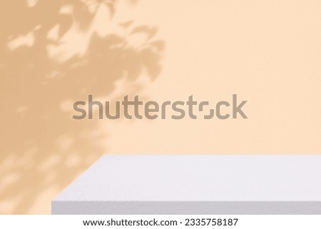 White Concrete Table Corner with Leaves on the Beige Concrete Wall Background, Suitable for Product Presentation Backdrop, Display, and Mock up. Royalty-Free Stock Photo #2335758187